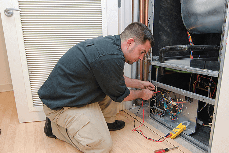 A man works on a ductless system. What Maintenance Is Needed for a Ductless System?